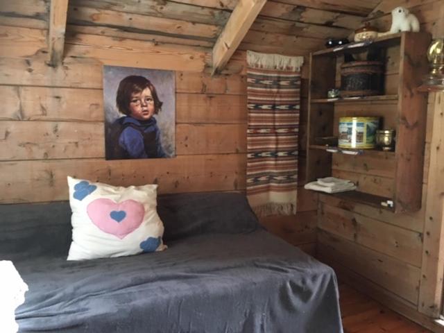 a room with a bed with a painting of a child at Josygaard in Austefjorden