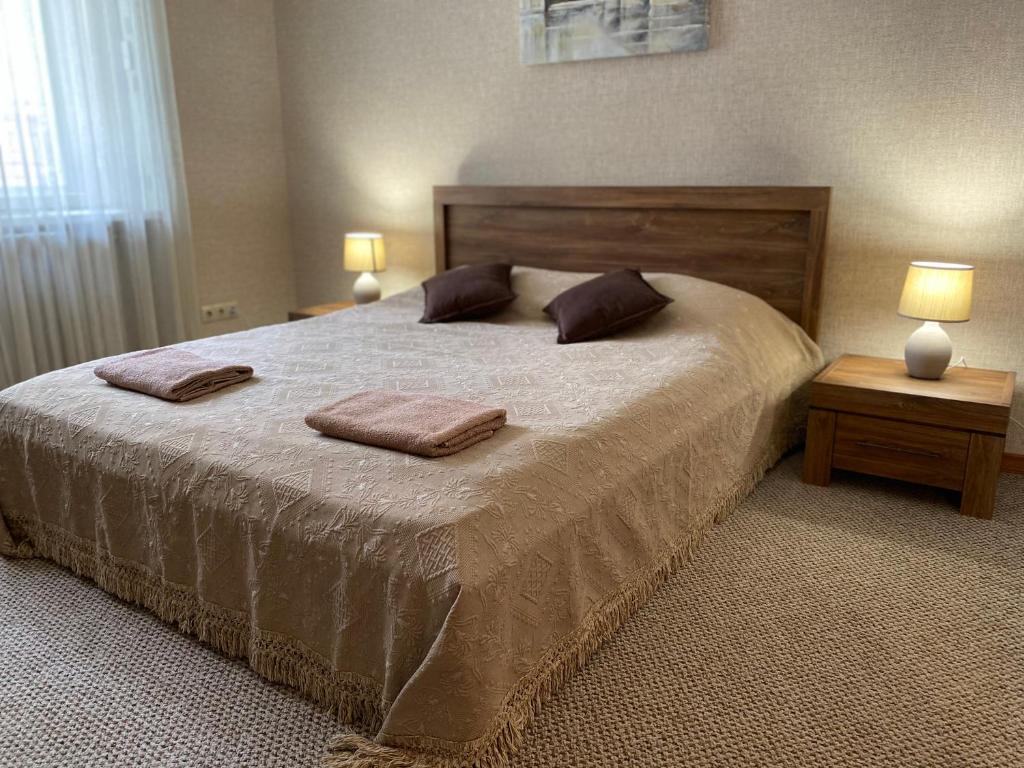 una camera da letto con un grande letto con due cuscini sopra di Family Apartment a Lviv