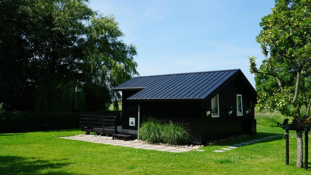 Emmelsbüll-HorsbüllにあるFerienhaus Achtern Diekの庭黒屋根の黒小屋