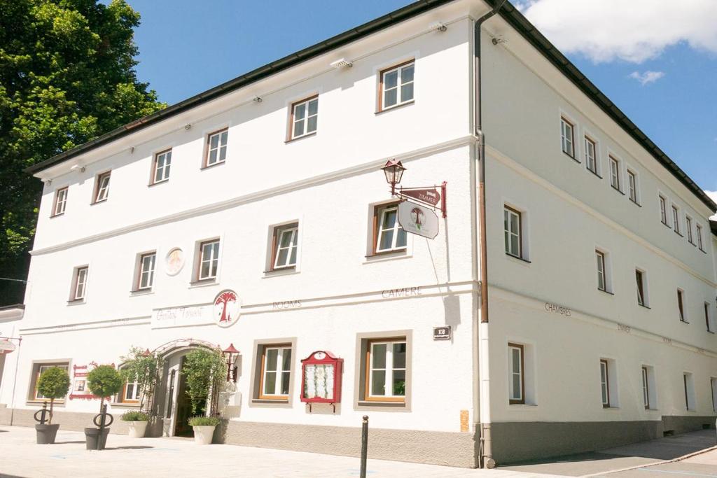 un grand bâtiment blanc sur le côté d'une rue dans l'établissement Gasthof Torwirt Radstadt, à Radstadt