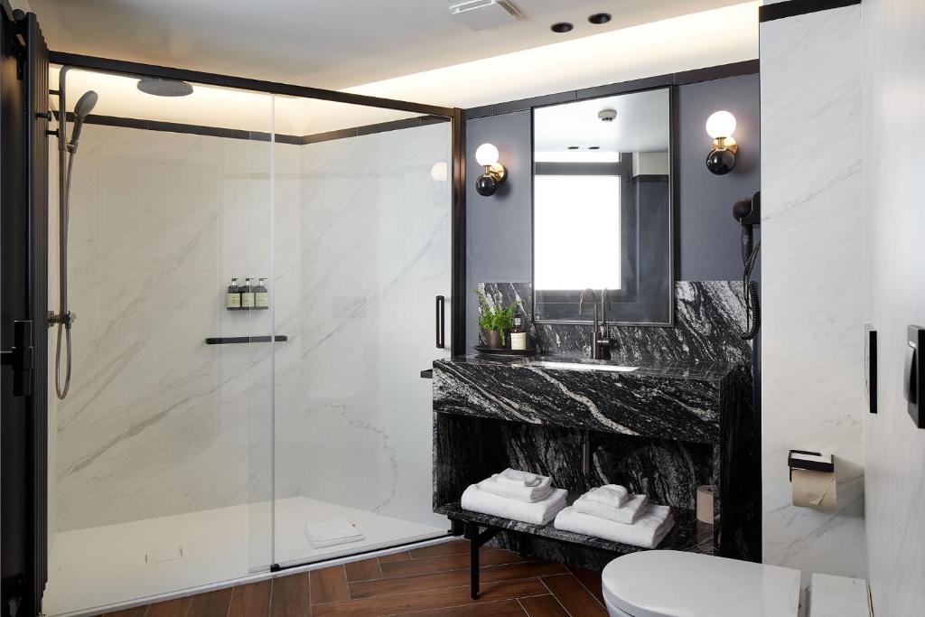 a bathroom with a shower and a sink at Hotel SANSEbay in Donostia-San Sebastián