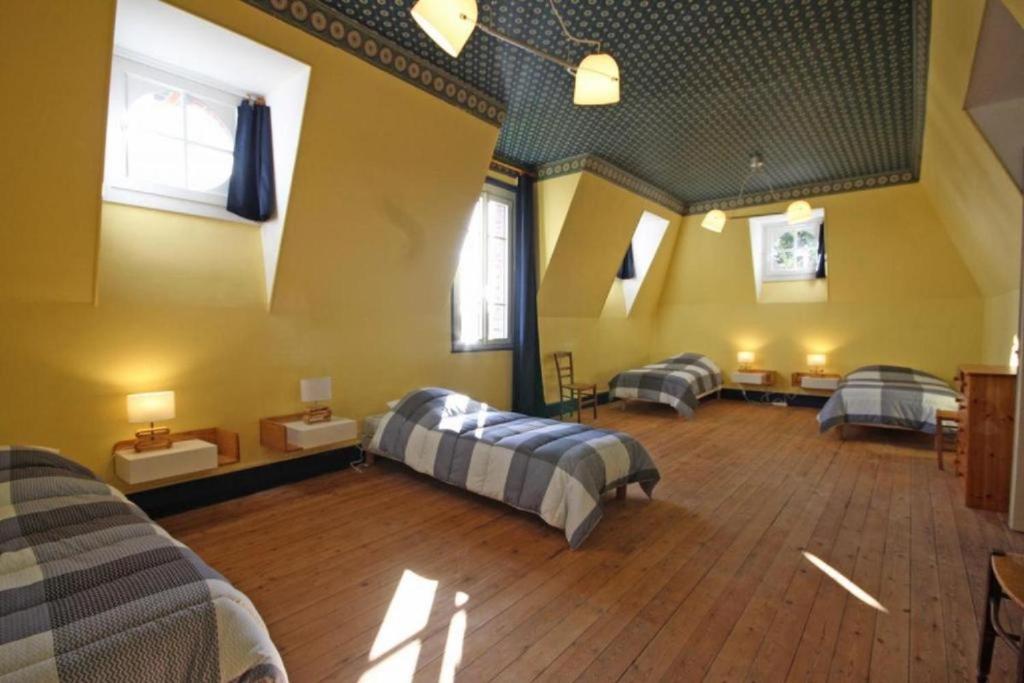 um quarto amplo com 2 camas e 2 cadeiras em Normandie 12 couchages em LʼAigle