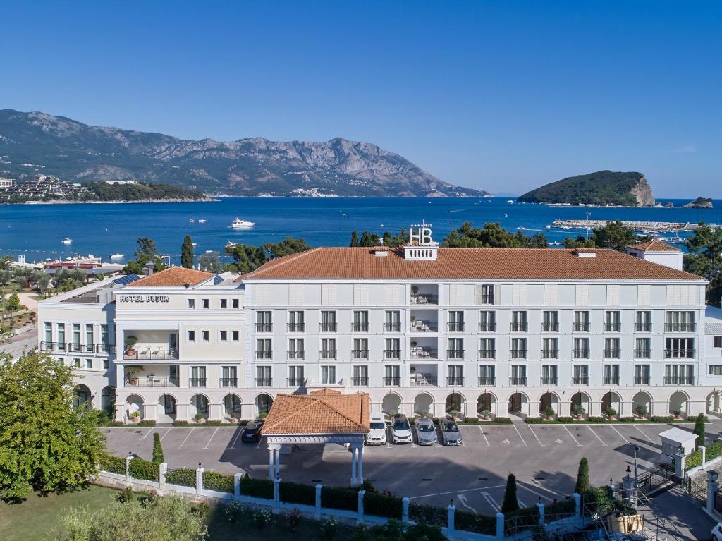 an aerial view of a large white building with a lake at Hotel Budva in Budva