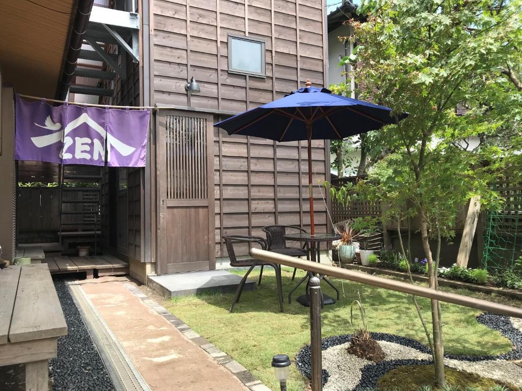a patio with a table and an umbrella at Guest House Kamakura Zen-ji in Kamakura