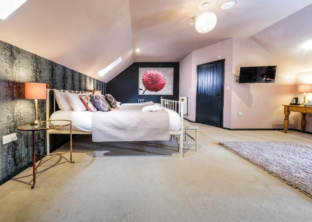 a bedroom with a large bed and a tv at The Westleton Crown in Westleton