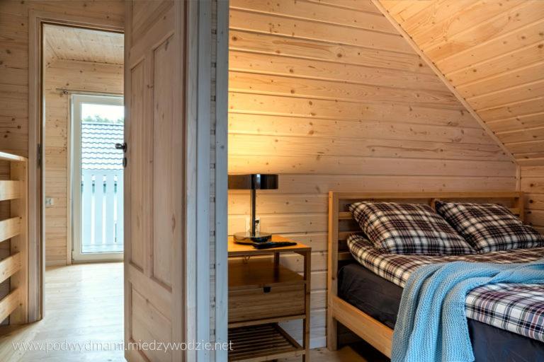 a log cabin bedroom with a bed and a desk at Domki Pod Wydmami in Międzywodzie