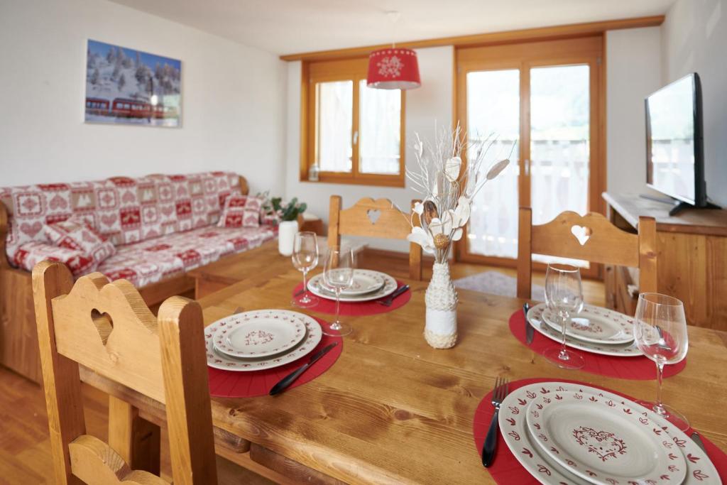 uma sala de estar com uma mesa com pratos e copos em Magnifique appartement aux Diablerets avec vue imprenable em Les Diablerets