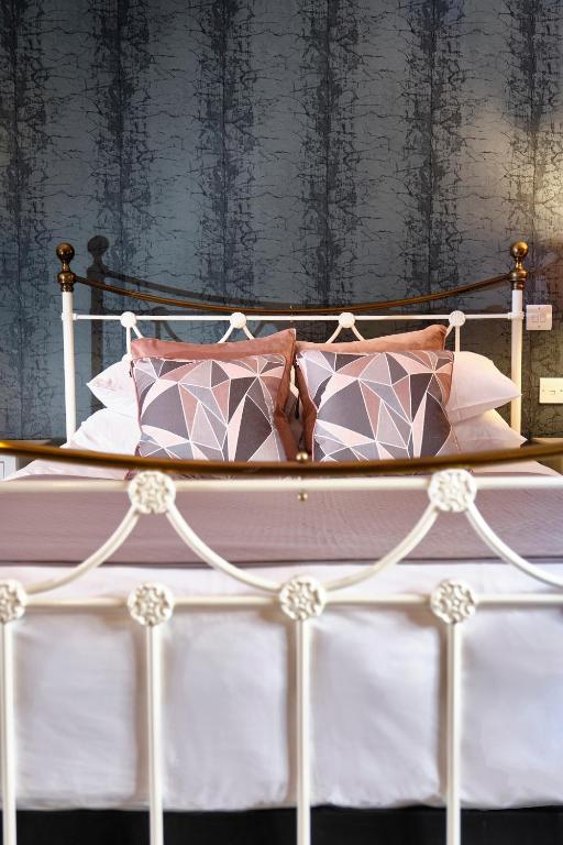 a bed with pink and white pillows on it at The Westleton Crown in Westleton