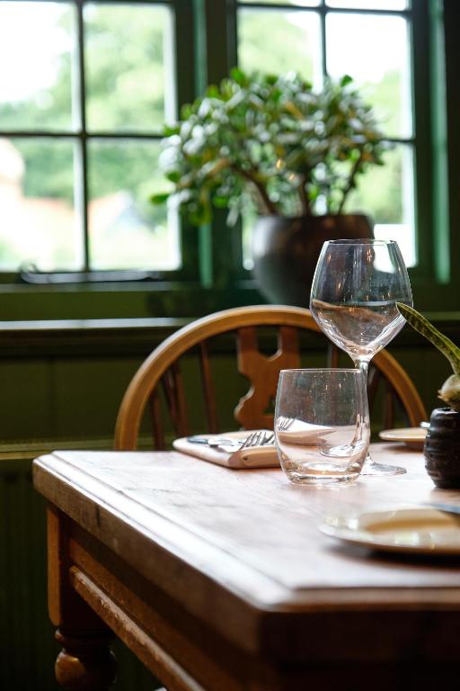 a table with two wine glasses on top of it at The Westleton Crown in Westleton