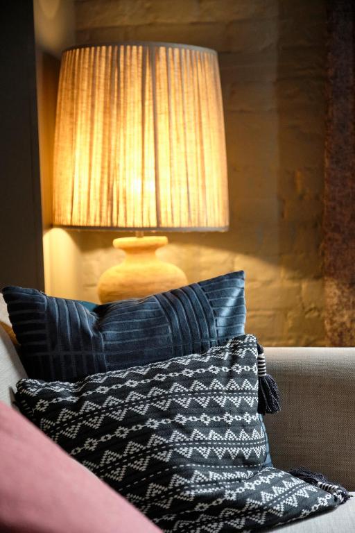 a lamp sitting on top of a couch with a pillow at The Westleton Crown in Westleton