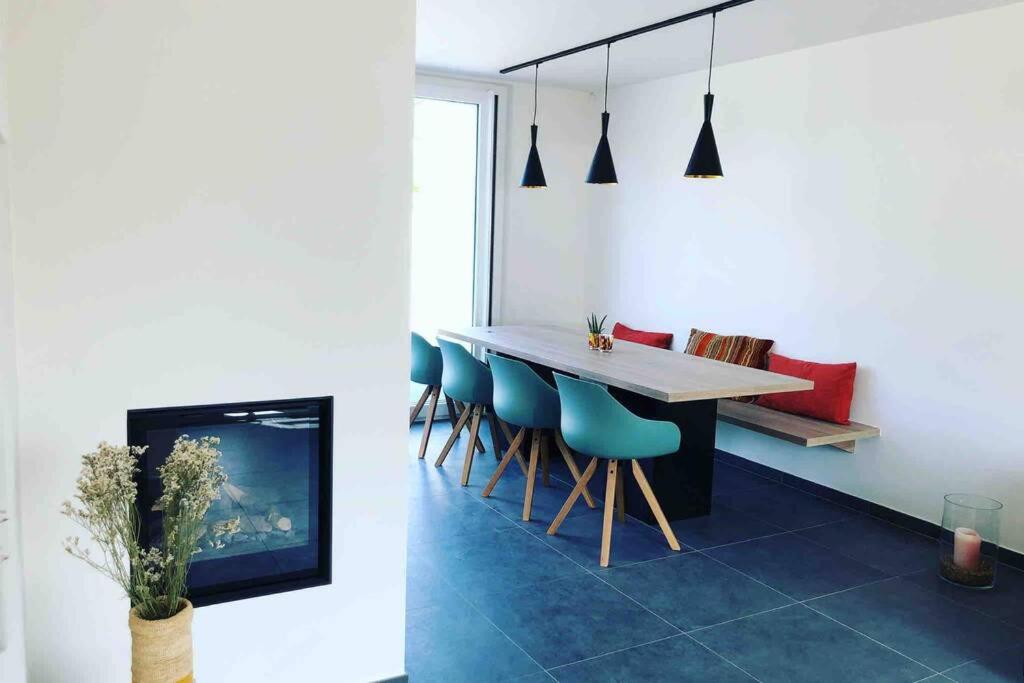 a dining room with a table and blue chairs at Die huis 14-Een oase van rust tussen polders en kust in Ostend