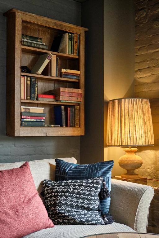 a living room with a couch and a book shelf at The Westleton Crown in Westleton
