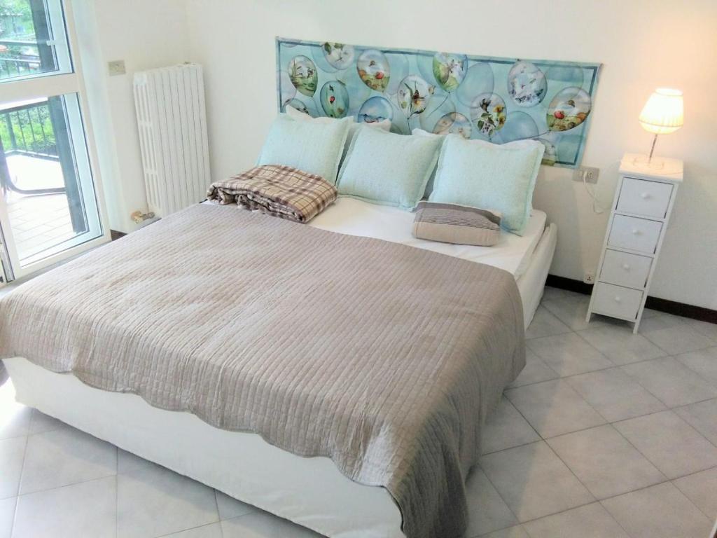 Un dormitorio con una cama grande en una habitación con ventana. en lago dorato, en Dervio