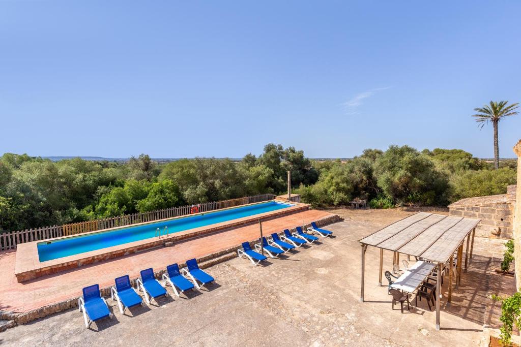 a swimming pool with lounge chairs and a table and a picnic table at Ses Cases Noves in Sa Ràpita