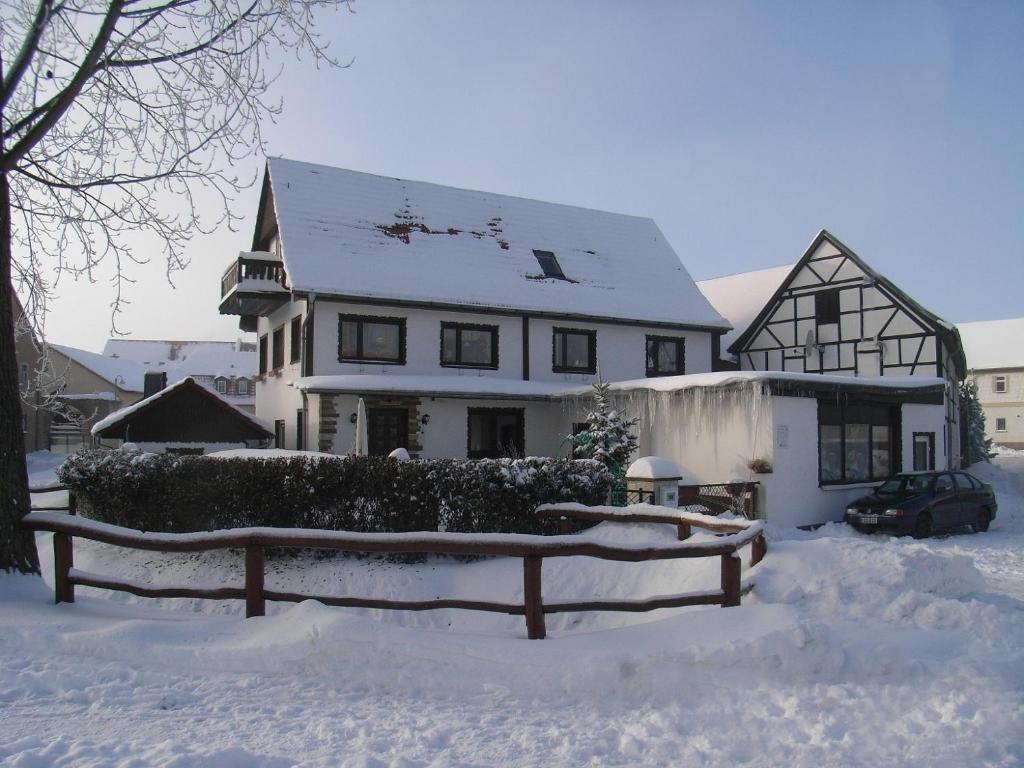 a snow covered house with a fence in front of it at Ferienwohnung Freund in Weimar