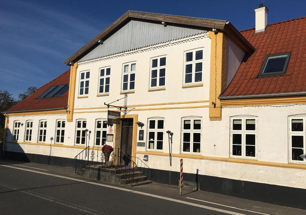 un gran edificio blanco con techo rojo en Fladbro Kro, en Randers