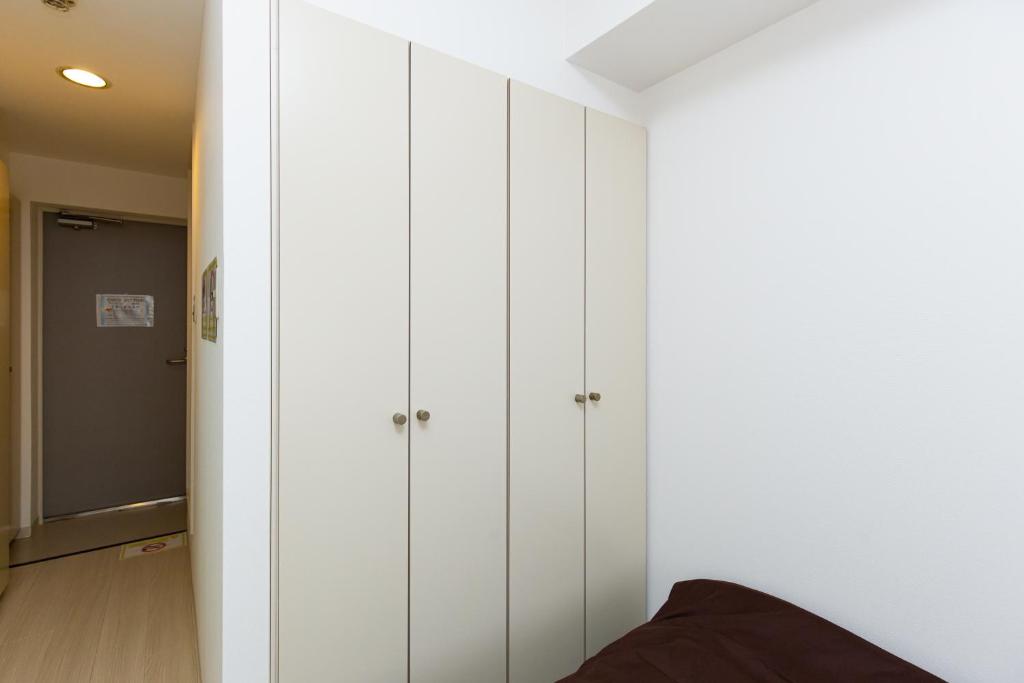 una fila de armarios blancos en una habitación en Asset Kita-Hatsutomi #MVx, en Kamagaya