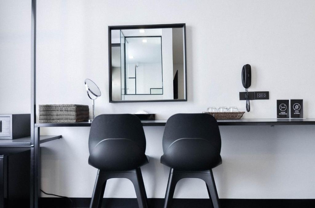 A two-seat vanity or work counter with a mirror, telephone and drinking glasses.
