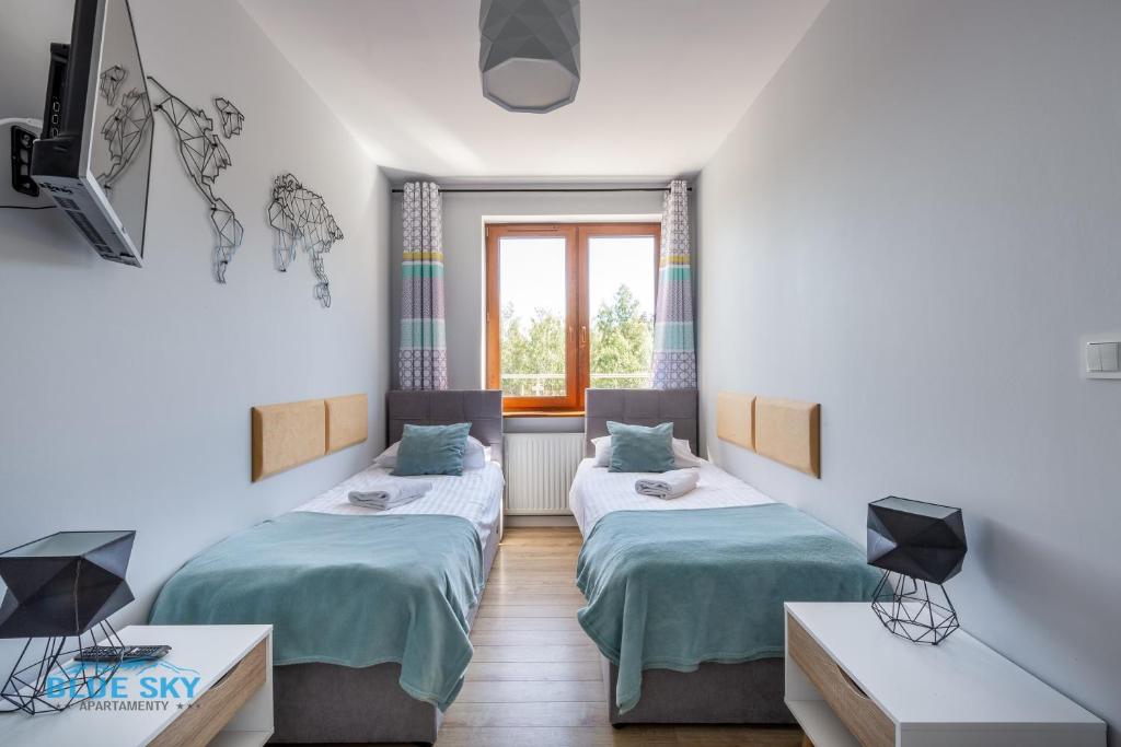 Postel nebo postele na pokoji v ubytování Apartamenty BlueSky - Ogrodnicza 7 i 9 - z widokiem na góry, w zielonej okolicy, blisko centrum i atrakcji Karpacza