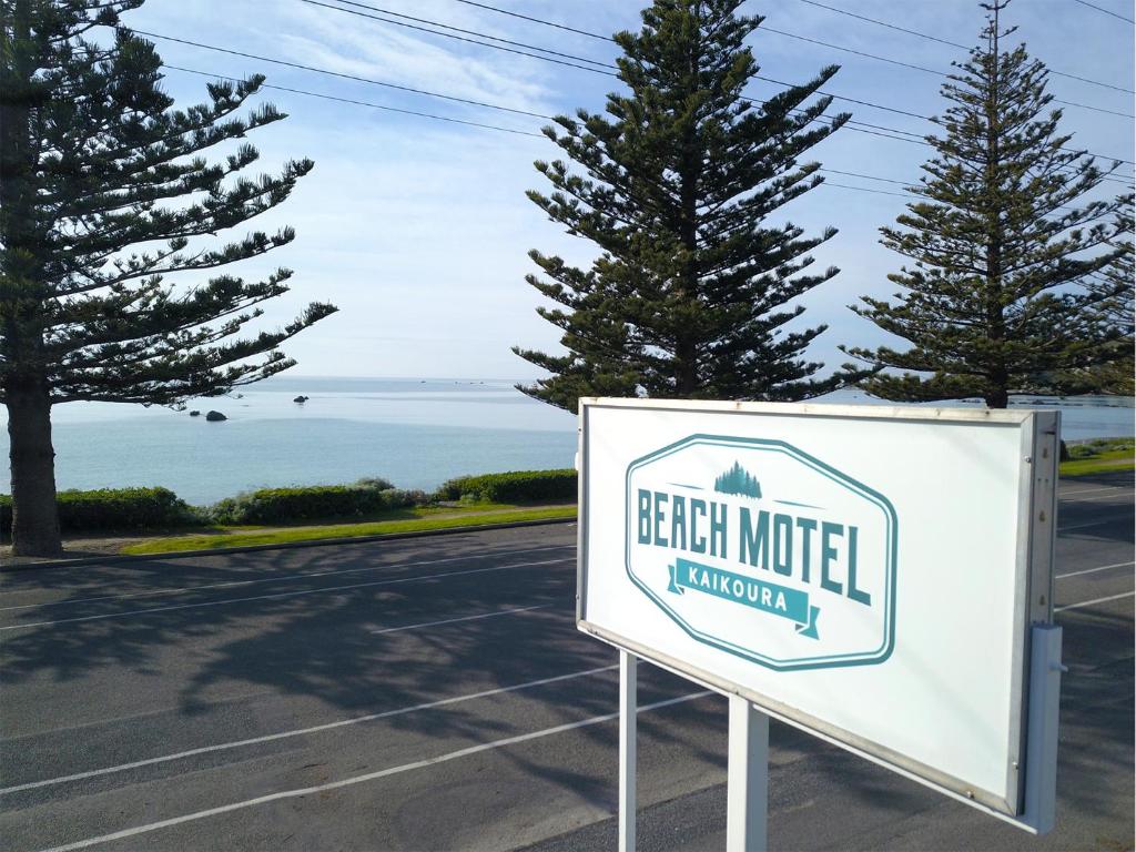 a sign for a beach motel next to the ocean at Kaikoura Beach Motel in Kaikoura