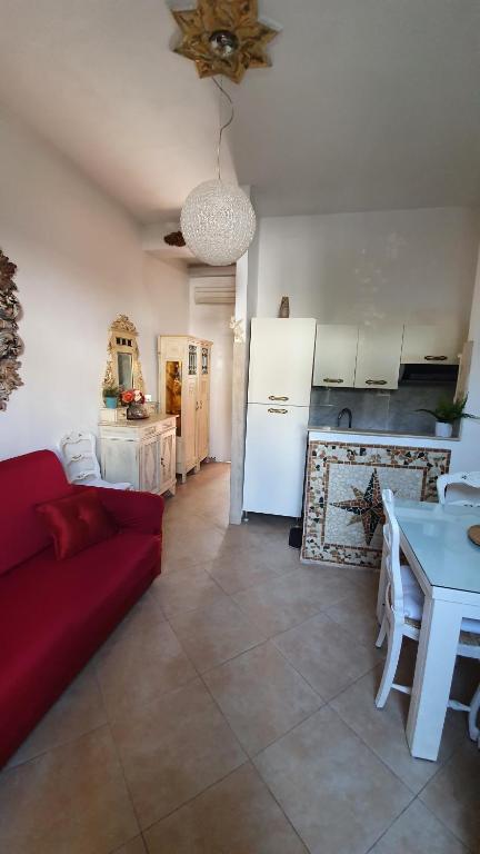 un salon avec un canapé rouge et une cuisine dans l'établissement MERLO 2 mare & parking, à Viareggio