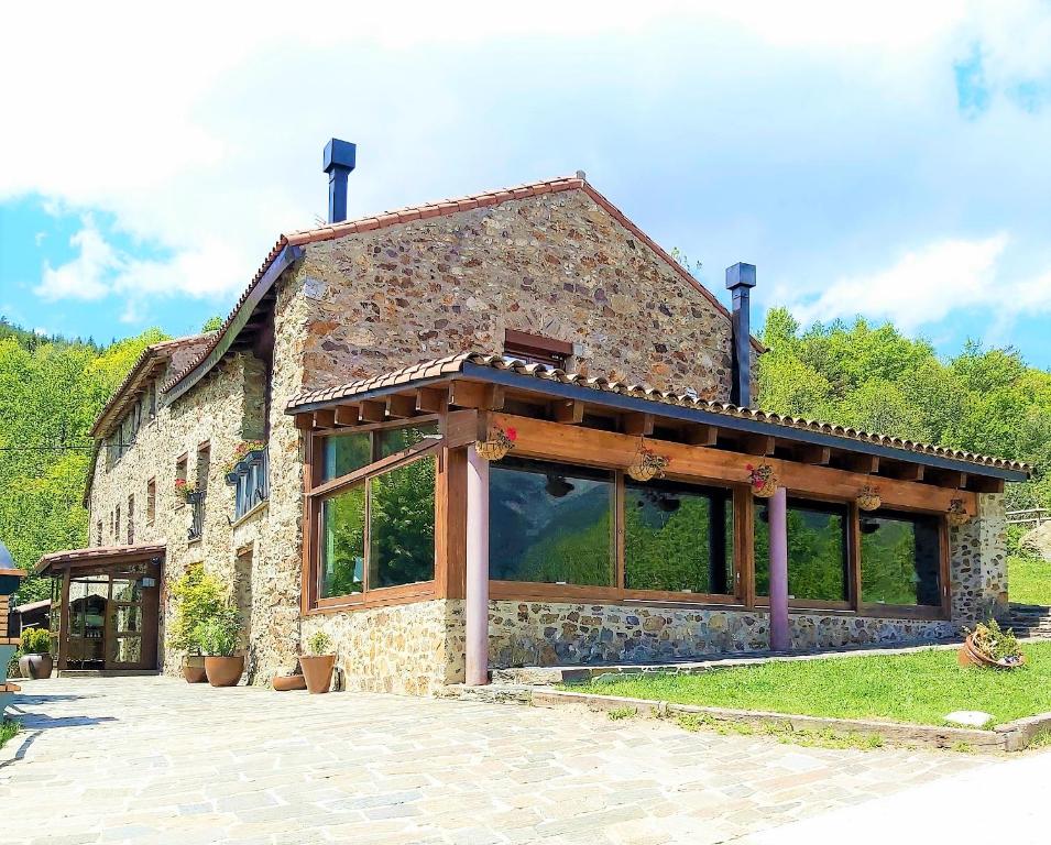 a large stone building with a large group of windows at Can Gasparó HotelRural&Restaurant in Planoles