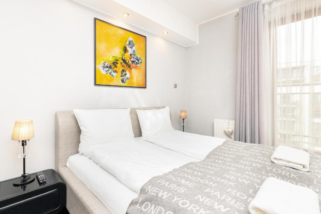 a white bedroom with a bed and a window at Apartments Gdańsk Drzewieckiego by Renters in Gdańsk