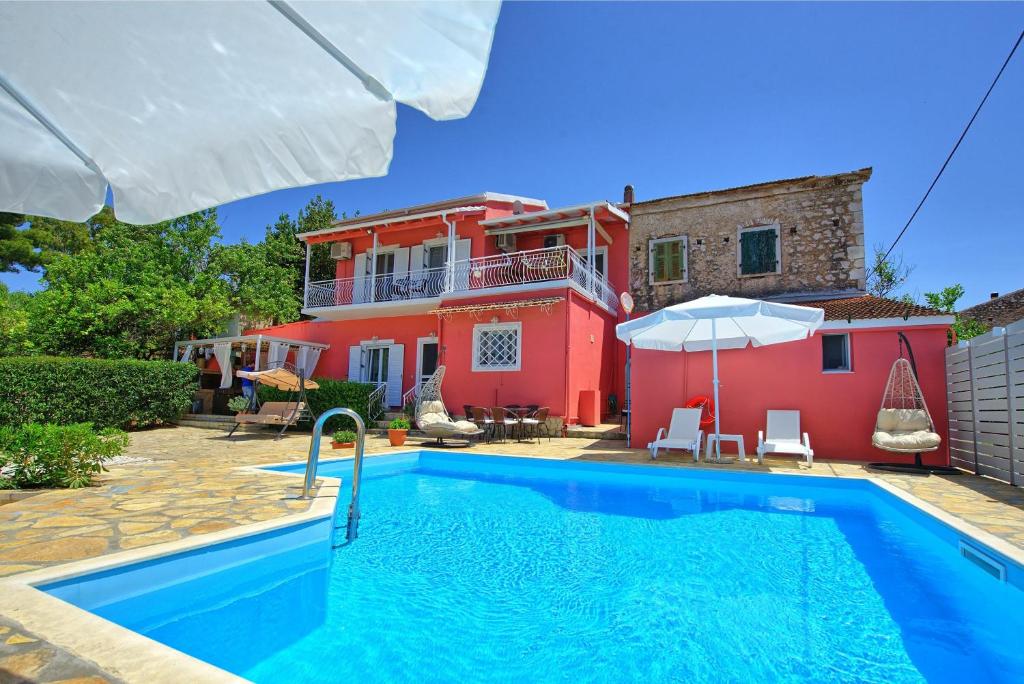 a villa with a swimming pool in front of a house at Villa Giador by PosarelliVillas in Perítheia