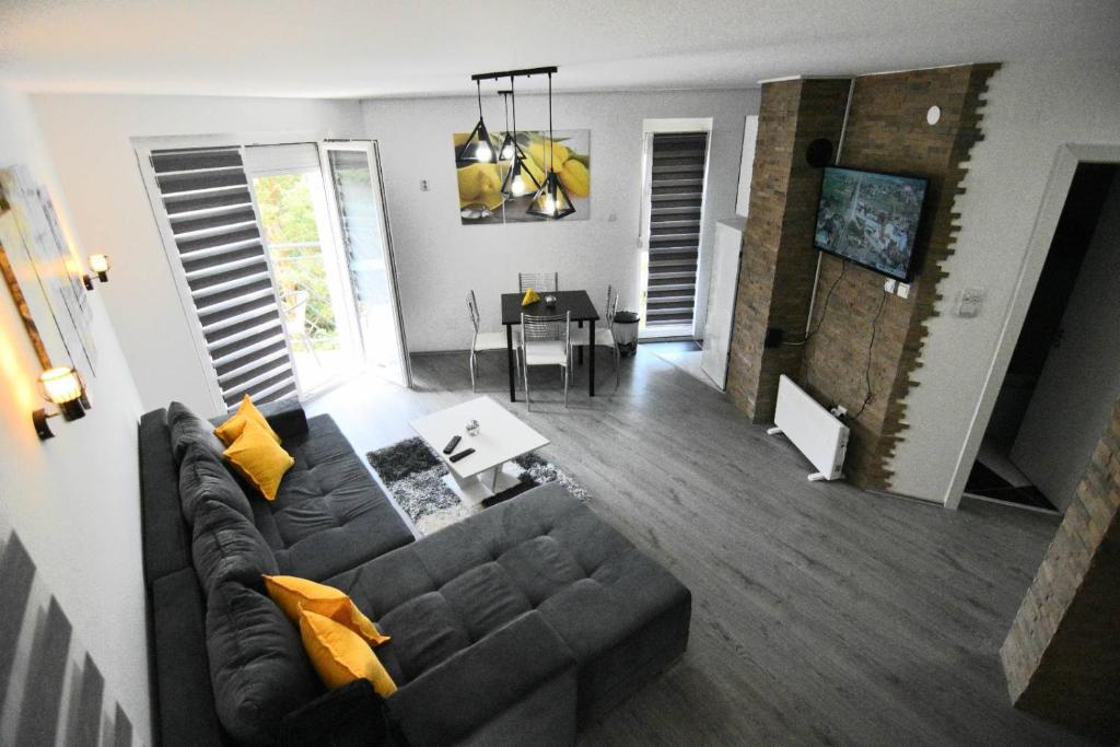 ein Wohnzimmer mit einem Sofa und einem Tisch in der Unterkunft Apartman Romana Duplex Divčibare in Divčibare