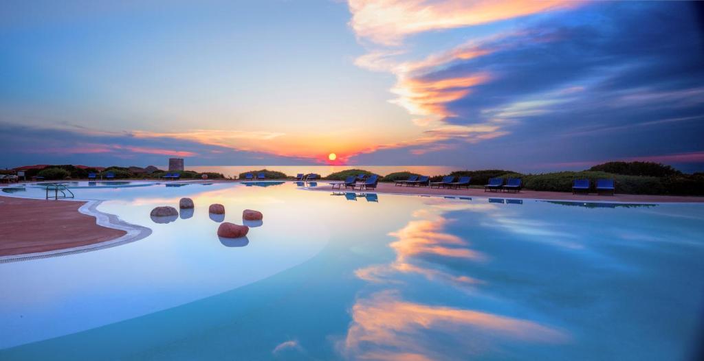 een weerspiegeling van de zonsondergang in een zwembad bij Hotel Relax Torreruja Thalasso & Spa in Isola Rossa
