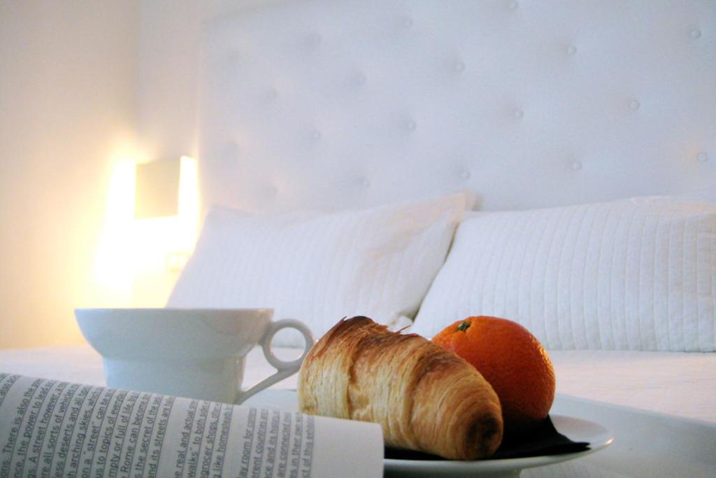 a plate with a croissant and an orange on a table at Hotel Salus in Pescara