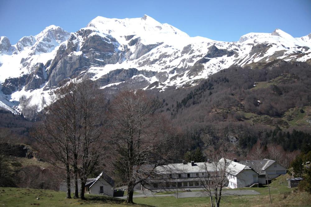 una casa frente a una montaña cubierta de nieve en Peyranère en Urdos