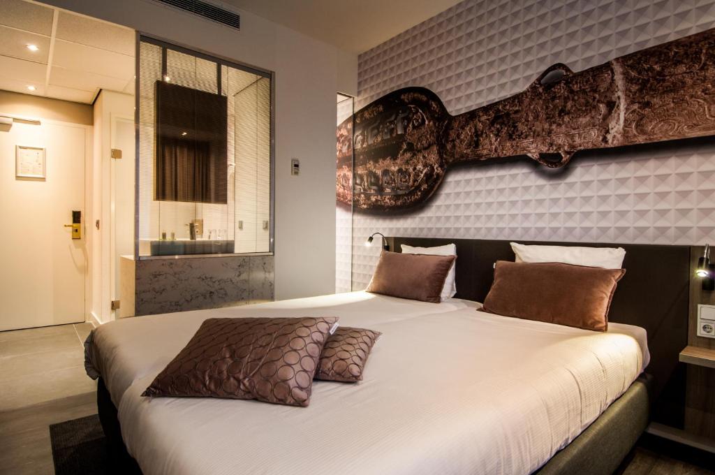 Uma cama ou camas num quarto em Golden Tulip Leiden Centre