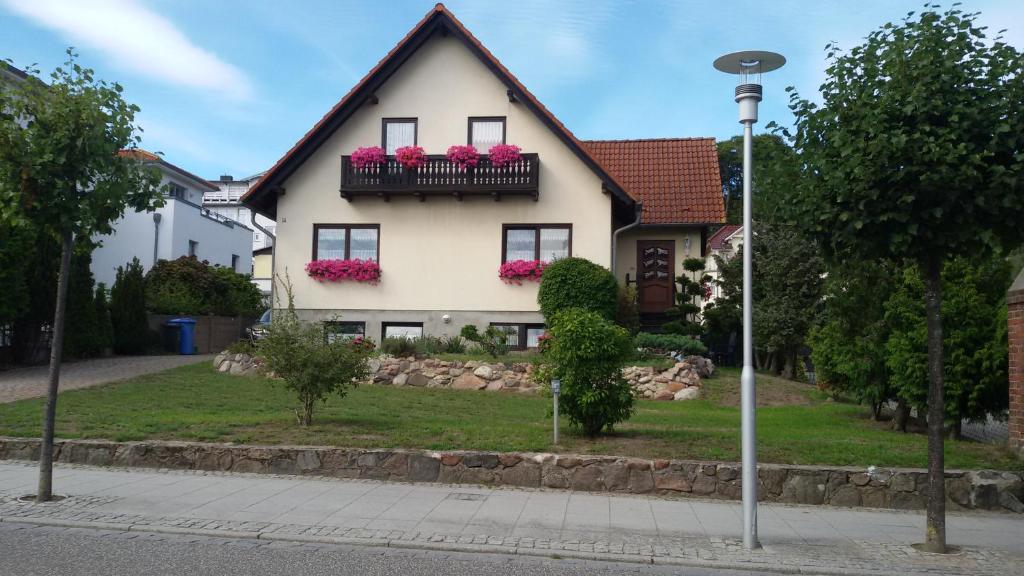 een huis met roze bloembakken op de ramen bij Ferienwohnungen Aemy in Ostseebad Sellin