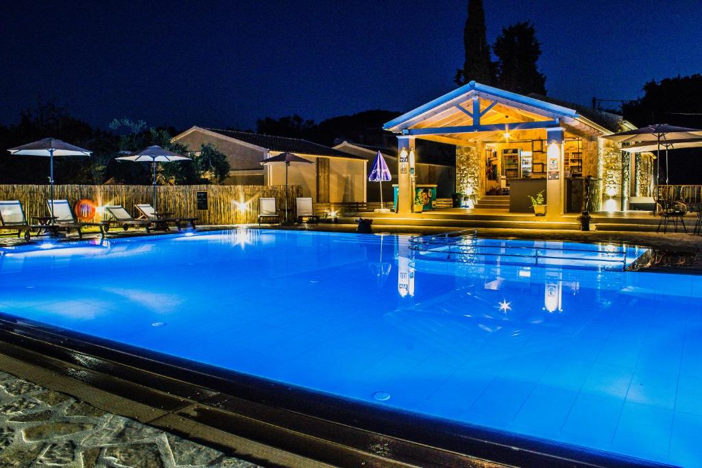 Astrakeroula Corfu في Astrakeri: حمام سباحة أزرق كبير في الليل