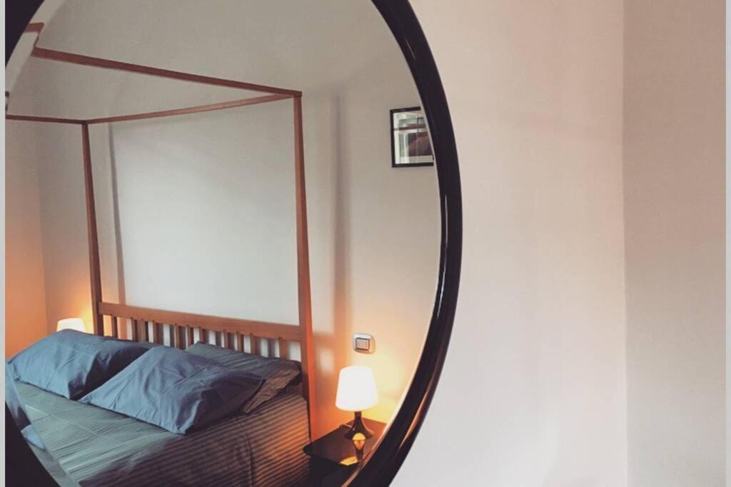 uno specchio in una camera con letto e lampada di House Bologna Stazione Mazzini flat x 2 a Bologna
