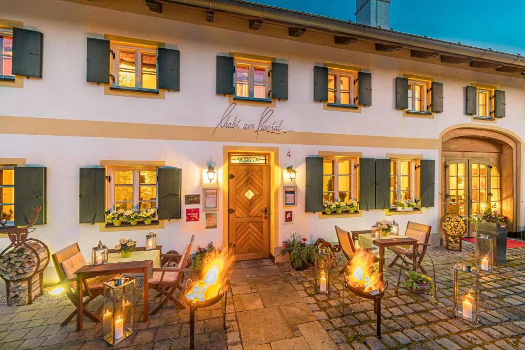 ein Gebäude mit Tischen und Stühlen davor in der Unterkunft Romantik Hotel Chalet am Kiental in Herrsching am Ammersee