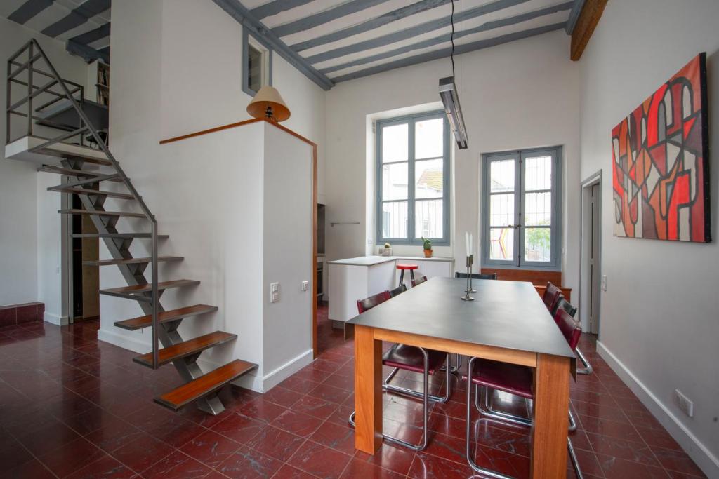 une cuisine avec une table et un escalier en colimaçon dans l'établissement Pavleo, à Paris