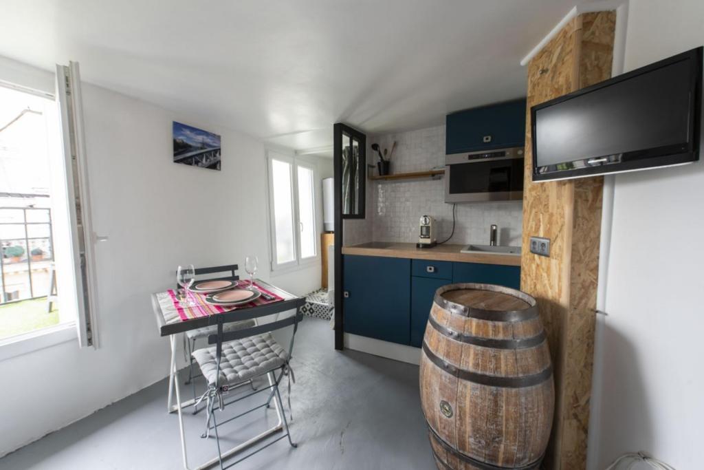 uma cozinha com uma mesa e um barril num quarto em Piaf em Paris