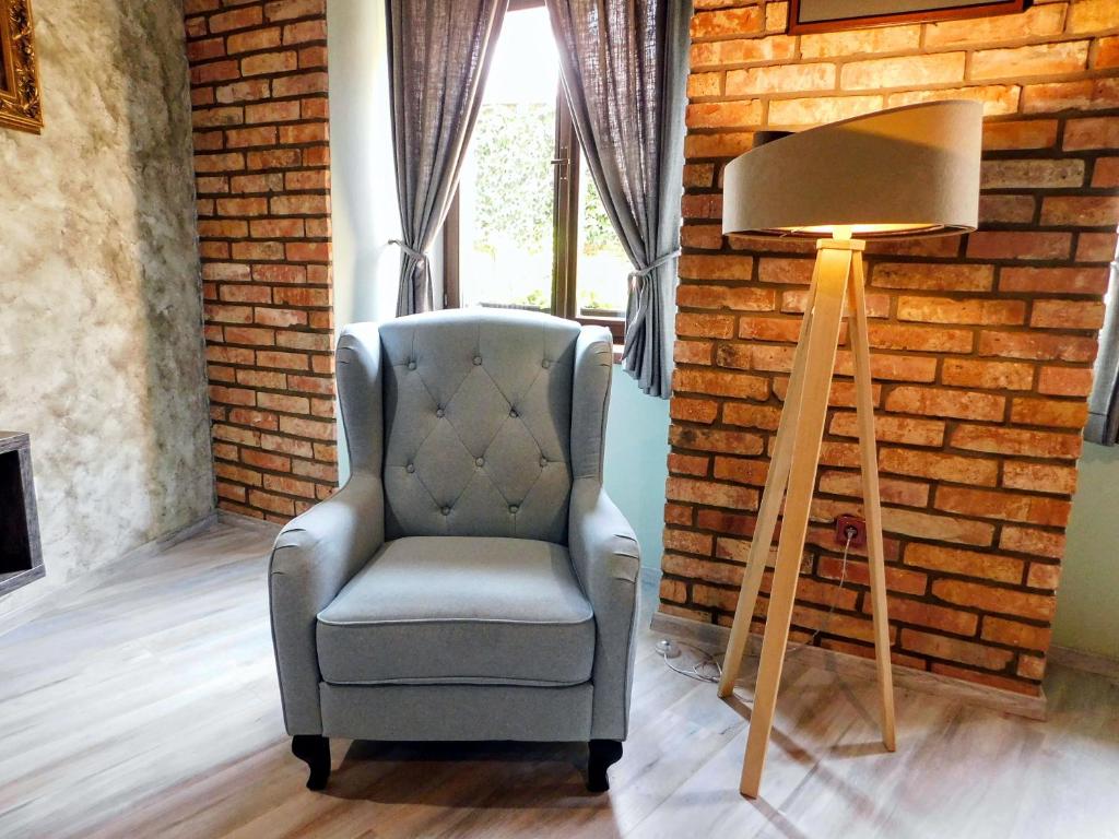 krzesło i lampa obok ściany z cegły w obiekcie U Paluku w mieście Chrudim