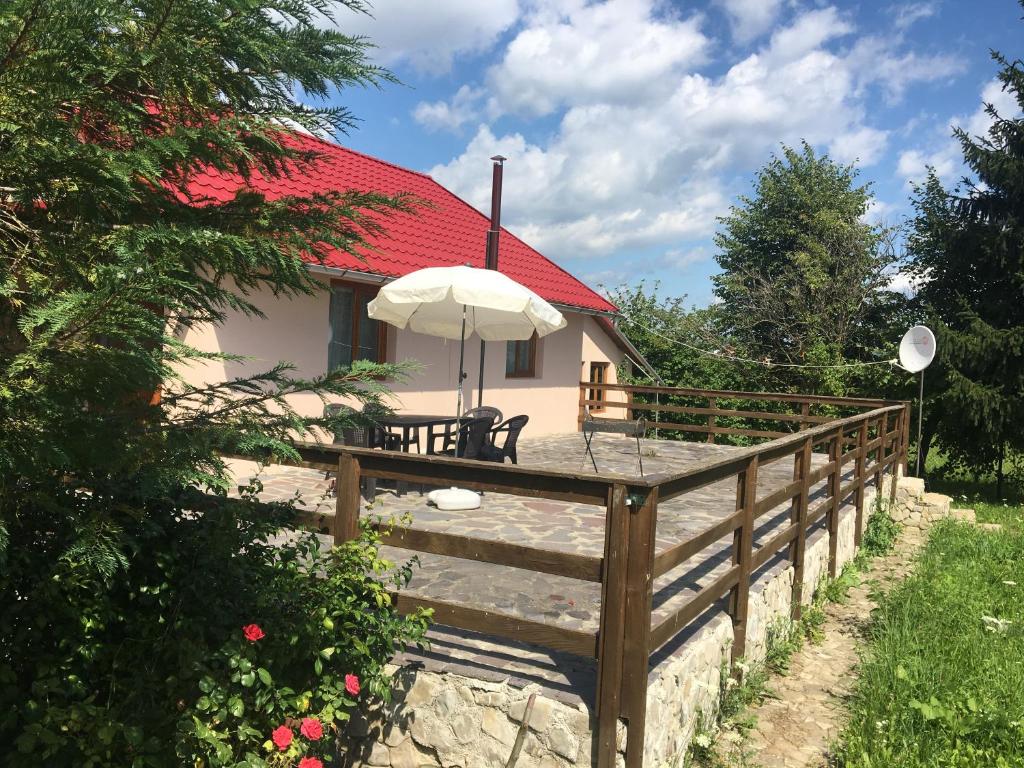 Casa con terraza de madera con sombrilla en CABANA CU MESTECENI Varatec en Văratec