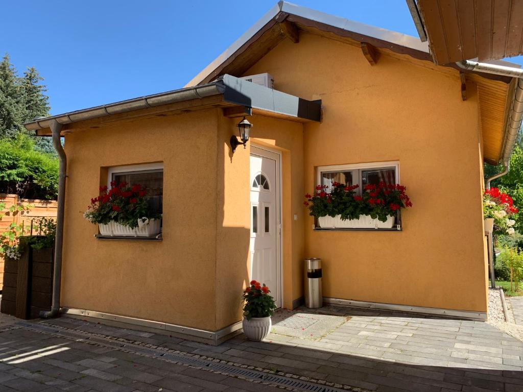Una casa con dos ventanas con flores. en Ferienhaus am Goldbach en Freiberg