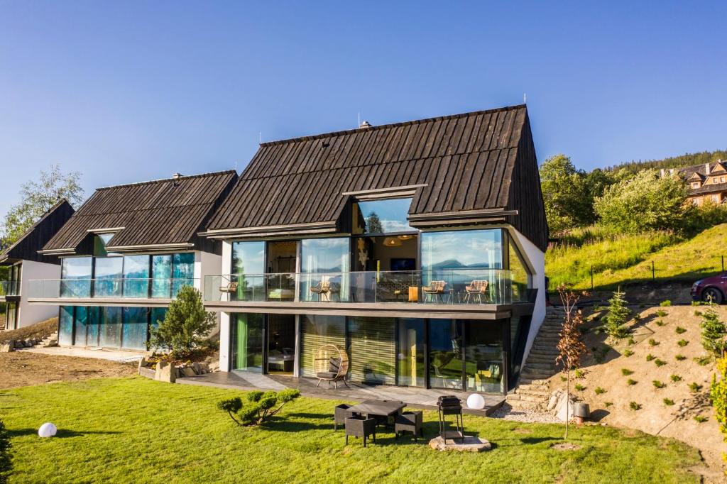 a large house with a black roof at udanypobyt OMG Houses in Kościelisko