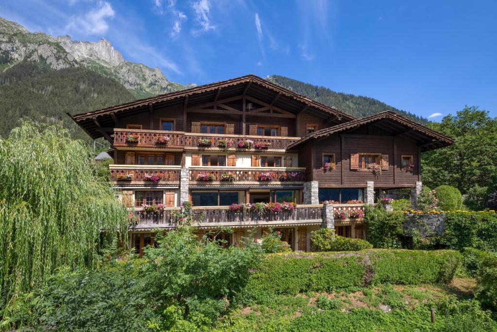 a large building with balconies and flowers in front at Auberge du Bois Prin in Chamonix