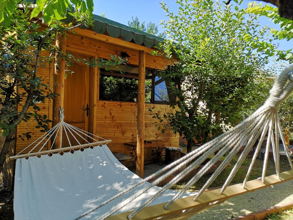 a hammock in front of a log cabin at Relax Eaza - Casa cu Hamac in Constanţa