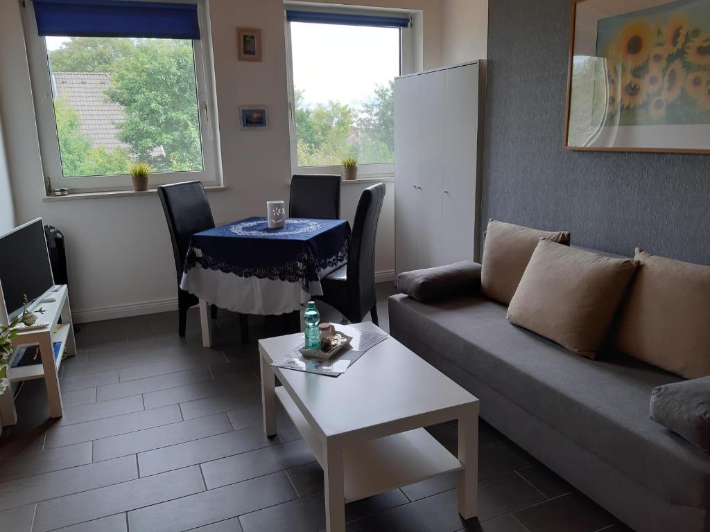 uma sala de estar com um sofá e uma mesa em Ferienwohnung Nesthäkchen em Hanerau-Hademarschen