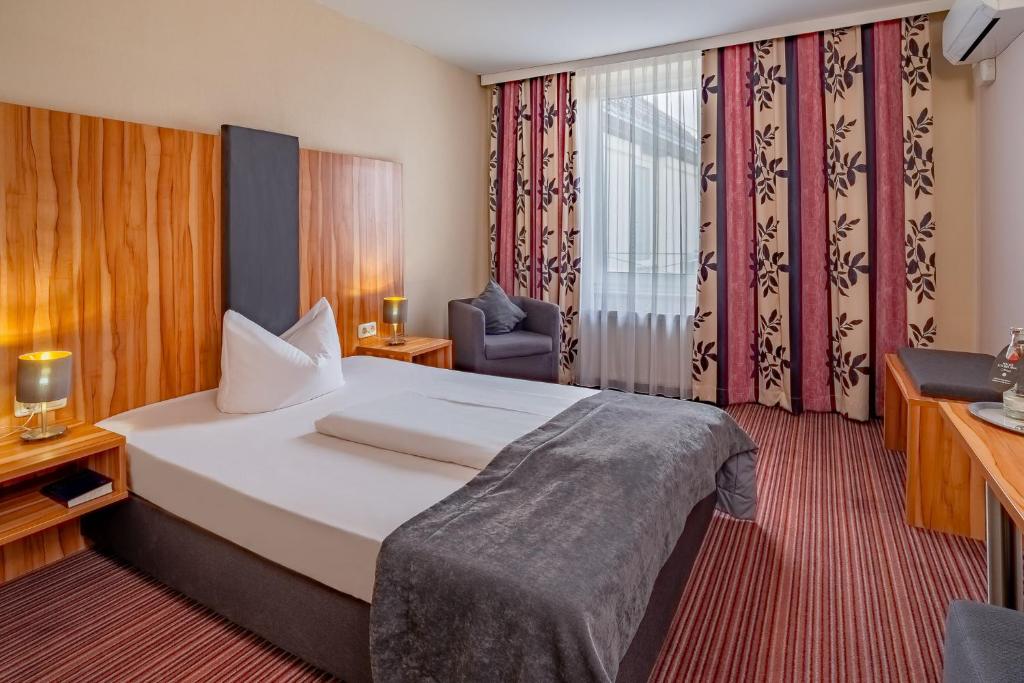 Postel nebo postele na pokoji v ubytování Arthotel ANA Style Augsburg
