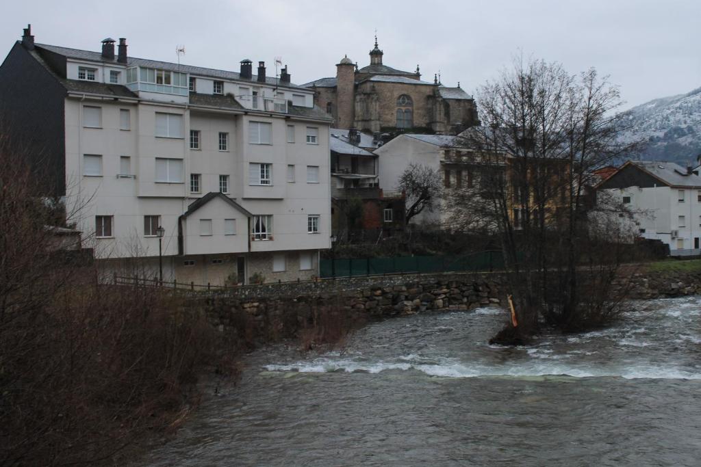 een groep gebouwen naast een rivier bij Hostal Burbia in Villafranca del Bierzo