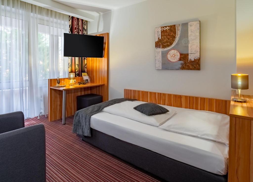 Postel nebo postele na pokoji v ubytování Arthotel ANA Style Augsburg