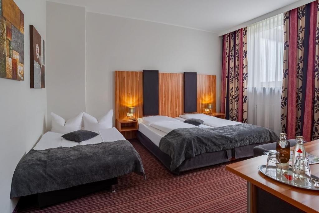Postel nebo postele na pokoji v ubytování Arthotel ANA Style Augsburg